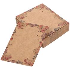 two pieces of brown paper with floral designs on the bottom and one piece is torn off