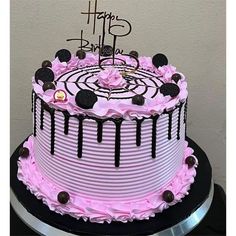 a birthday cake decorated with pink and black icing