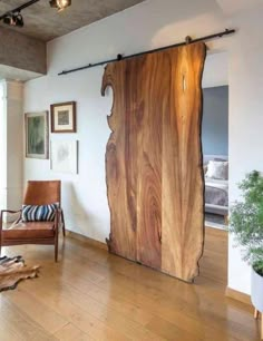 a living room filled with furniture and a large piece of wood on top of a hard wood floor