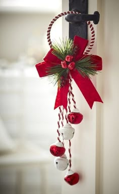 a door handle decorated with bells and christmas decorations hanging from it's side wall