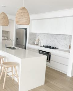 a kitchen with white counter tops and wooden stools