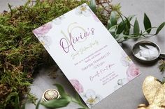 the wedding stationery is surrounded by greenery