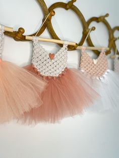 three tutu skirts hanging on a clothes line with wooden pegs in the background