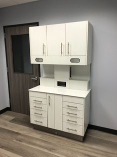 an empty office with white cabinets and drawers