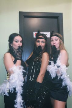 three women dressed in black and white posing for the camera