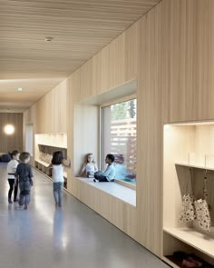 two children are looking out the window in a store with wooden walls and shelving