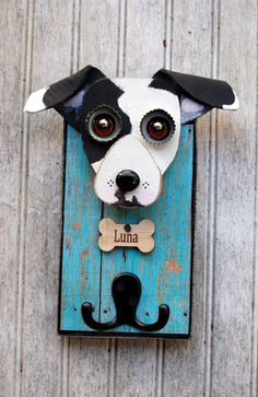 a dog with a bone in its mouth is mounted on a wooden plaque that says luna