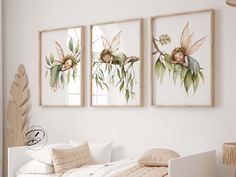 three paintings on the wall above a bed in a room with white walls and pillows