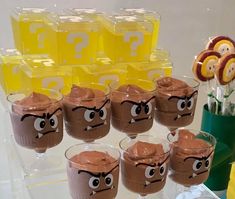 there are many glasses that have chocolate pudding in them with googly eyes on them