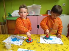 two young boys are playing with their art project