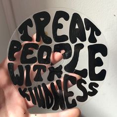 a person holding up a sticker with words on it