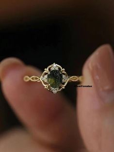 a close up of a person's hand holding a yellow and white diamond ring