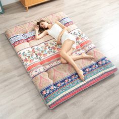 a woman laying on top of a colorful bed