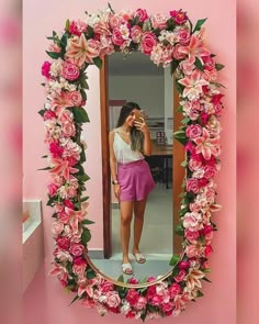 a woman taking a selfie in front of a mirror with pink flowers on it