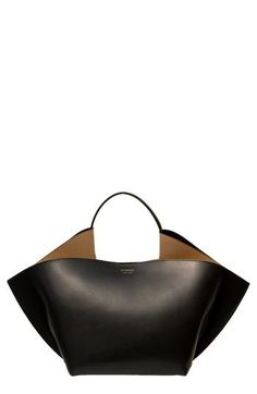 Defined by a freeform-sculpture silhouette and smooth calfskin leather, this Italian-made tote from Amsterdam-based designer Desiree Kleinen quietly impresses. The fluidly folded design provides ample carrying capacity, and the runner-reinforced base keeps everything on an even keel. Magnetic closure Top carry handle Structured silhouette with flat base for stability Leather Made in Italy Designer Handbags Black Owned and Founded Fashion Job, Modern Handbag, Investment Bags, Fashion Jobs, Handbags Black, Stylish Purse, Oversized Tote Bag, Wholesale Bags, Fabric Gift Bags