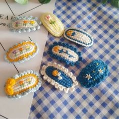 several crocheted objects are sitting on a blue and white checkered tablecloth