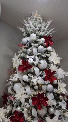 a white christmas tree with red and silver ornaments