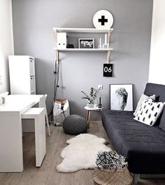 a living room with grey walls and white furniture in the corner, including a black couch