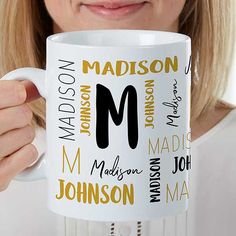 a woman is holding a coffee mug with the letter m in all its different languages