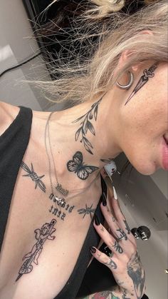 a woman with many tattoos on her chest and hand holding a cell phone to her ear