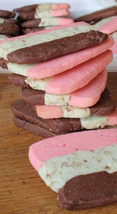 several cookies with pink and white frosting are stacked on top of each other in rows