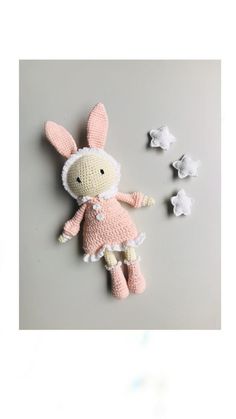 a crocheted stuffed animal laying on top of a table next to small white stars