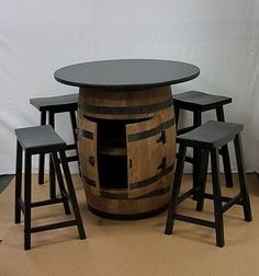 a wooden barrel table with stools around it