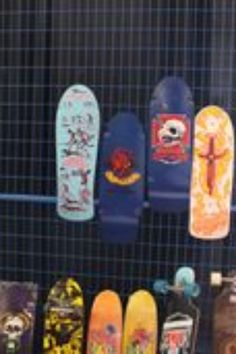 there are many skateboards lined up on the rack together in front of each other