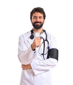 a man with a stethoscope in his hand and wearing a white coat