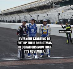 three men standing next to each other in front of a race track with the words everyone starting to put up their christmas decorations now that it's november