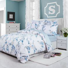 a bedroom with blue walls and white furniture