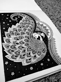 a black and white drawing of a peacock sitting on top of a piece of paper