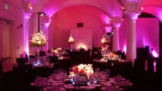 a banquet hall with purple lighting and decorated tables