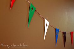 colorful paper buntings hanging from a line on a wall in a room with brown walls