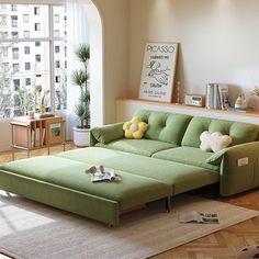 a living room filled with furniture and a large window covered in lots of natural light