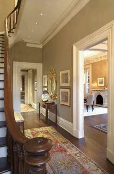 a staircase in a house with pictures on the wall and carpeted stairs leading up to it