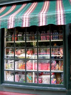 a store front with many different types of candy in the window and on the outside