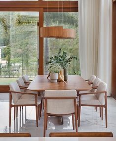 a dining room table with chairs and a potted plant