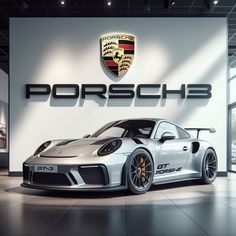 a porsche car is parked in front of a wall with the words porsche on it