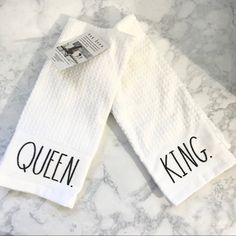 two white towels with the words queen and king on them sitting on a marble counter