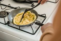 someone is cooking food on the stove with a skillet in front of them,