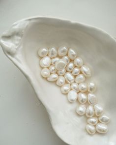 a white bowl filled with pearls on top of a table