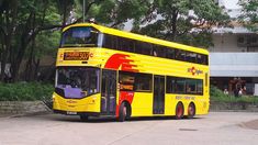 a yellow double decker bus parked in front of a building