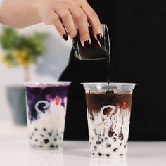 a woman pours coffee into two cups