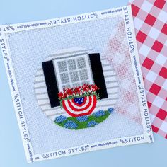 a cross stitch pattern with an american flag window and red, white, and blue gingham table cloth