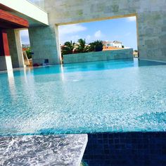 an empty swimming pool in front of a building with blue tiles on the floor and walls