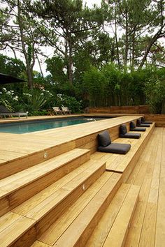 a wooden deck next to a swimming pool