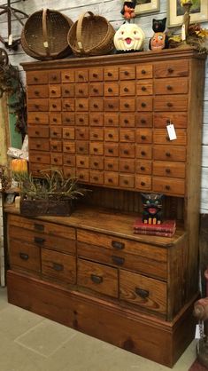 an old dresser with many drawers and baskets on top