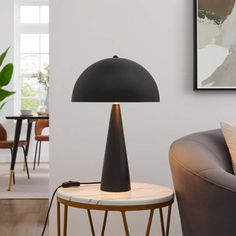 a black lamp sitting on top of a wooden table next to a brown chair in a living room