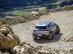 a silver car parked on top of a rocky hill